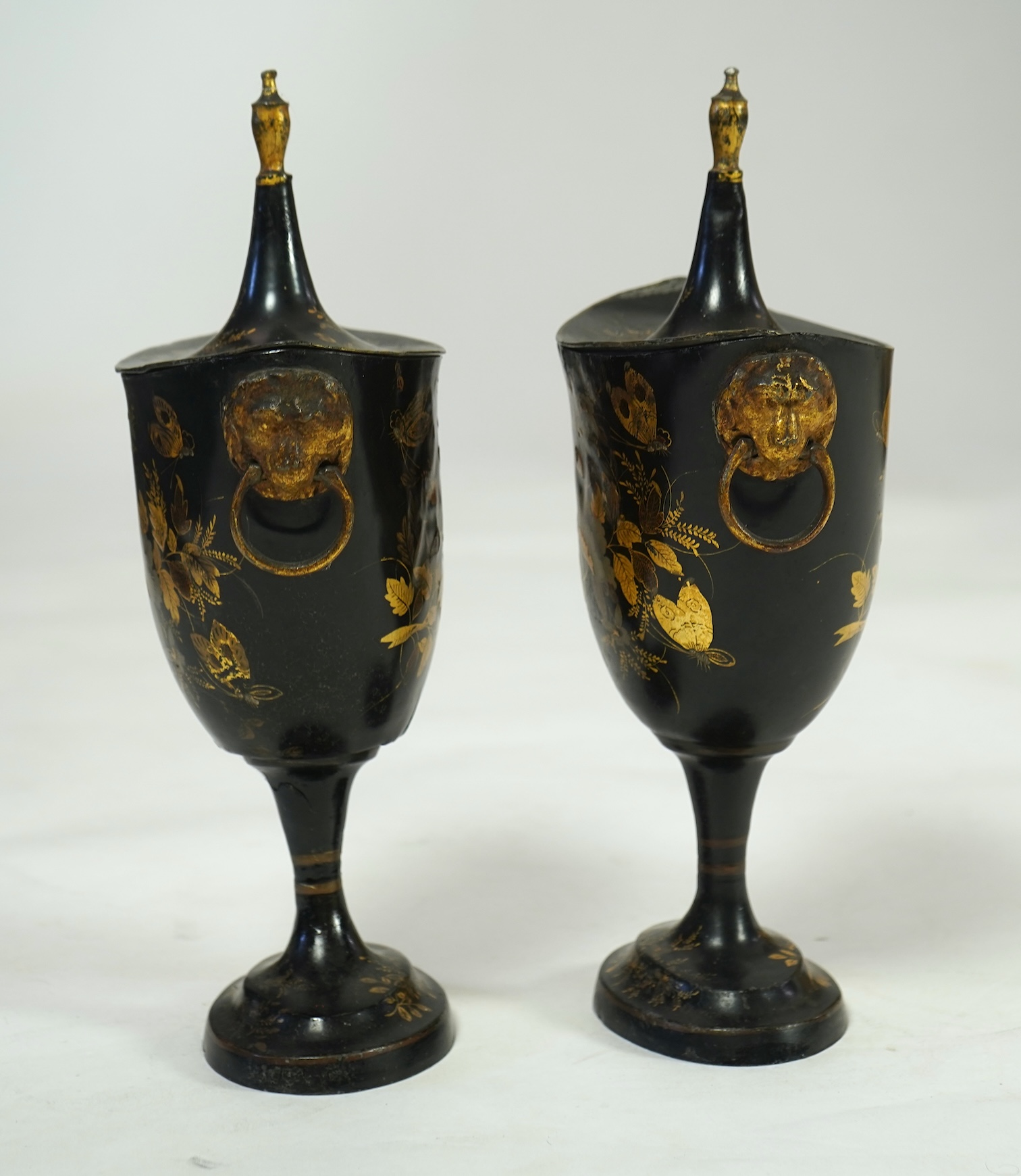 A pair of early 19th century Dutch japanned pewter chest urns and covers, and a tole ware cheese coaster
